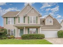 Two-story house with beige siding, green shutters, and a two-car garage at 4103 Desert Rose Ct, Fort Mill, SC 29708