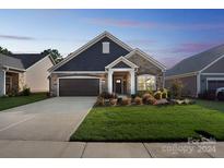 Craftsman style home with stone and siding, two-car garage, and landscaped lawn at 1346 Millview Ln, Matthews, NC 28104