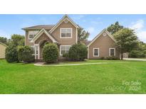 Two-story home with brown siding and green lawn at 15129 Dartford Ln, Mint Hill, NC 28227