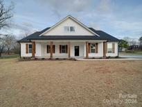 White farmhouse exterior with a covered front porch and dark brown columns at 4020 Landsford Rd, Marshville, NC 28103
