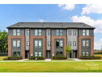 Three-unit townhome development showcasing modern brick exteriors and landscaping at 3014 Khan Park Dr # 67, Charlotte, NC 28206