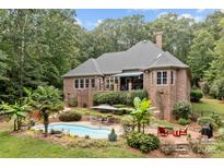 Inviting pool area with lush landscaping and patio furniture at 4364 Hager Mountain Ln, Iron Station, NC 28080