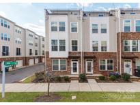 Three-story brick townhome with modern design, front porch, and landscaping at 448 E 16Th St, Charlotte, NC 28206