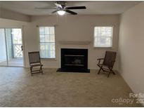 Cozy living room featuring a fireplace and two chairs, perfect for relaxation at 19831 Henderson Rd # C, Cornelius, NC 28031