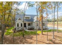 Craftsman style home with stone accents and a spacious front porch at 310 Scalybark Trl, Concord, NC 28027