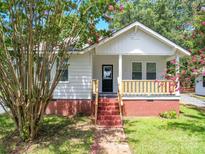 Charming white cottage with a red brick porch and steps at 450 Cherry St, Wadesboro, NC 28170