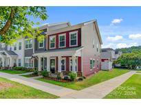 Two-story townhome with red and gray siding, front porch, and landscaping at 1801 Edgewater Nw Dr, Conover, NC 28613