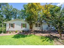 White ranch house with brown shutters, deck, and landscaped yard at 219 Rustic Hills Cir, Bessemer City, NC 28016