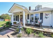 Inviting front porch with stone patio, fountain, and comfortable seating at 7514 Secrest Shortcut Rd, Indian Trail, NC 28079