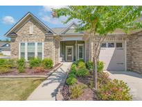 Inviting stone and shingle exterior, landscaped gardens, and a two-car garage at 3087 Bartlett St, Fort Mill, SC 29715