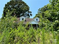 Brick house with overgrown vegetation, needs landscaping at 0 Nc Hwy 73 W Hwy, Mount Gilead, NC 27306