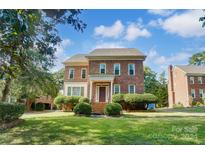 Brick two-story home with a manicured lawn at 6517 Hunter Pine Ln, Charlotte, NC 28270