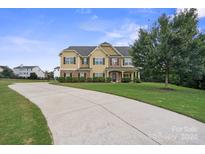 Two-story house with stone accents, large windows and a long driveway at 5601 Ballenger Ct, Waxhaw, NC 28173