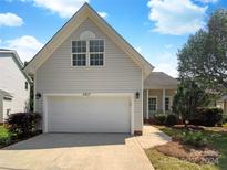 Beige house with white garage door and landscaping at 5617 Davis Ridge Dr, Charlotte, NC 28269