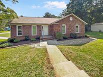 Brick ranch house with landscaped yard and walkway at 1669 Buckingham Ave, Gastonia, NC 28054