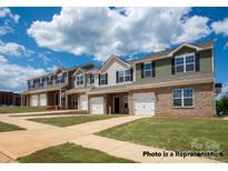 Townhouses with brick and siding, two-car garages, and landscaped lawns at 5332 Cherrie Kate Ct # 1703, Stanley, NC 28164