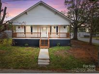 Charming white house with a wooden porch and a well-maintained lawn at 225 York Ave, Kannapolis, NC 28083