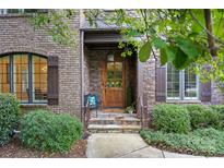 Inviting brick front entry with stone accents and a charming wooden door at 5942 Carmel Rd, Charlotte, NC 28226