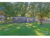Ranch style home with gray exterior and landscaped lawn at 335 Davidson Hwy, Concord, NC 28027