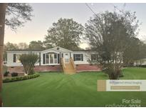 Single-wide mobile home with brick skirting, steps, and landscaped lawn at 2315 Circle Dr, Great Falls, SC 29055