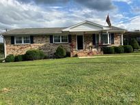 Brick ranch house with a well-maintained lawn and covered porch at 4040 Angus Dr, Gastonia, NC 28056