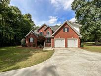 Brick house with a three-car garage and landscaping at 2510 Doster Rd, Monroe, NC 28112