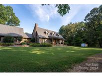 Two story brick home with a metal roof and landscaping at 1235 Bob Falls Dr, Shelby, NC 28150