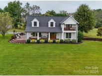 Two story home with white exterior, dark roof, and a large front porch at 540 Harbor Rd, Norwood, NC 28128