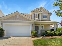 Two-story house with beige siding, white garage door, and landscaping at 10305 Shrader Nw St, Concord, NC 28027