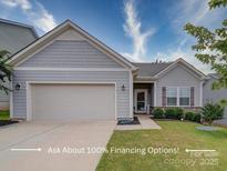 Gray siding one-story house with attached garage, landscaping, and walkway at 165 Old Harbor Dr, Mount Gilead, NC 27306