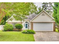 Single-story home with a white garage door and green lawn at 4428 Hounds Run Dr, Matthews, NC 28105