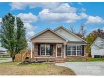 Brick ranch home with landscaping and a paved driveway at 1205 Danielle Downs Ct, Concord, NC 28025