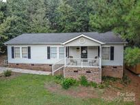 Single-story home with front porch and landscaping at 394 Link Dr, Iron Station, NC 28080