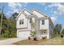 Two-story white house with a two-car garage and landscaping at 7118 Plott Rd, Charlotte, NC 28215