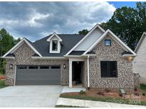 Brick home with gray two-car garage and landscaping at 1 Beth Haven Church Rd, Denver, NC 28037