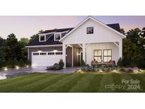 Modern farmhouse exterior with gray siding and charming porch at 4820 Reason Ct # 67, Harrisburg, NC 28075