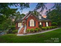 Brick home with landscaping and a large window at 14001 Cabarrus Station Rd, Midland, NC 28107