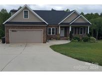 Single-story home with a two-car garage and landscaped yard at 3486 Mason Spring Dr, Lincolnton, NC 28092