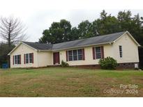 Ranch style home with neutral siding, red shutters, and a landscaped lawn at 8885 Brandon Cir, Concord, NC 28025