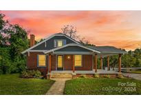 Brick house with gray trim, covered porch, and yard at 2523 Kool Park Ne Rd, Hickory, NC 28601
