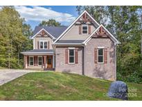 Two-story home with brick and siding exterior, large windows, and front porch at 3171 Stonemill Path, Sherrills Ford, NC 28673