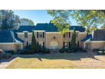 Brick townhouse with a teal roof and well-maintained landscaping at 7021 Quail Hill Rd, Charlotte, NC 28210