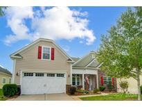 Tan house with white garage doors and red shutters at 8928 Carneros Creek Rd, Charlotte, NC 28214