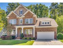 Brick home with two-car garage and inviting front porch at 1909 Madeira Cir, Waxhaw, NC 28173