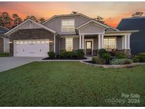 Two-story house with stone accents and a landscaped lawn at 2716 Manor Stone Way, Indian Trail, NC 28079