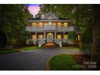 Grand two-story brick home with a charming front porch and landscaping at 10250 Barringer Ct, Mount Pleasant, NC 28124