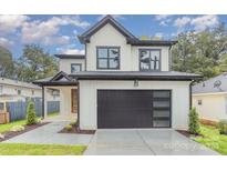 Modern two-story house with white siding, dark garage door, and landscaping at 2305 Sanders Ave, Charlotte, NC 28216