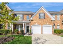 Brick front exterior of charming townhome with two-car garage and manicured landscaping at 5066 Ashford Crest Ln, Charlotte, NC 28226