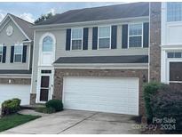 Two-story townhome with a white garage door at 7308 Gallery Pointe Ln, Charlotte, NC 28269