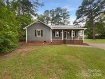 Gray house with brick base, covered porch, and landscaped yard at 2403 Sutters Rd, Concord, NC 28027